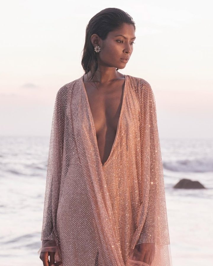 Model in a sheer sequinned kaftan on the shore at dusk