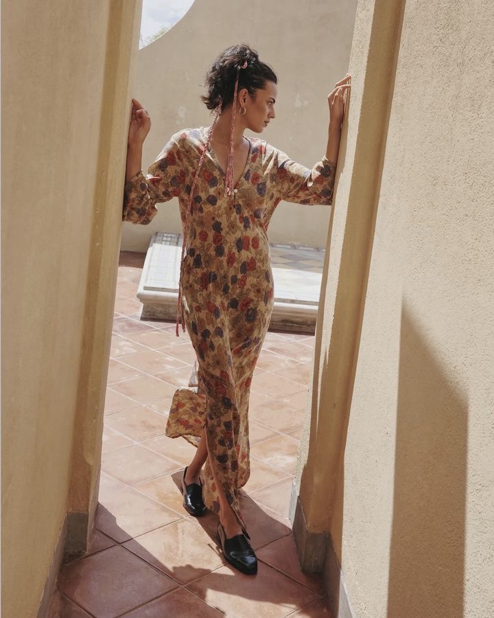 Model in a floral maxi dress framed by a terrace passage